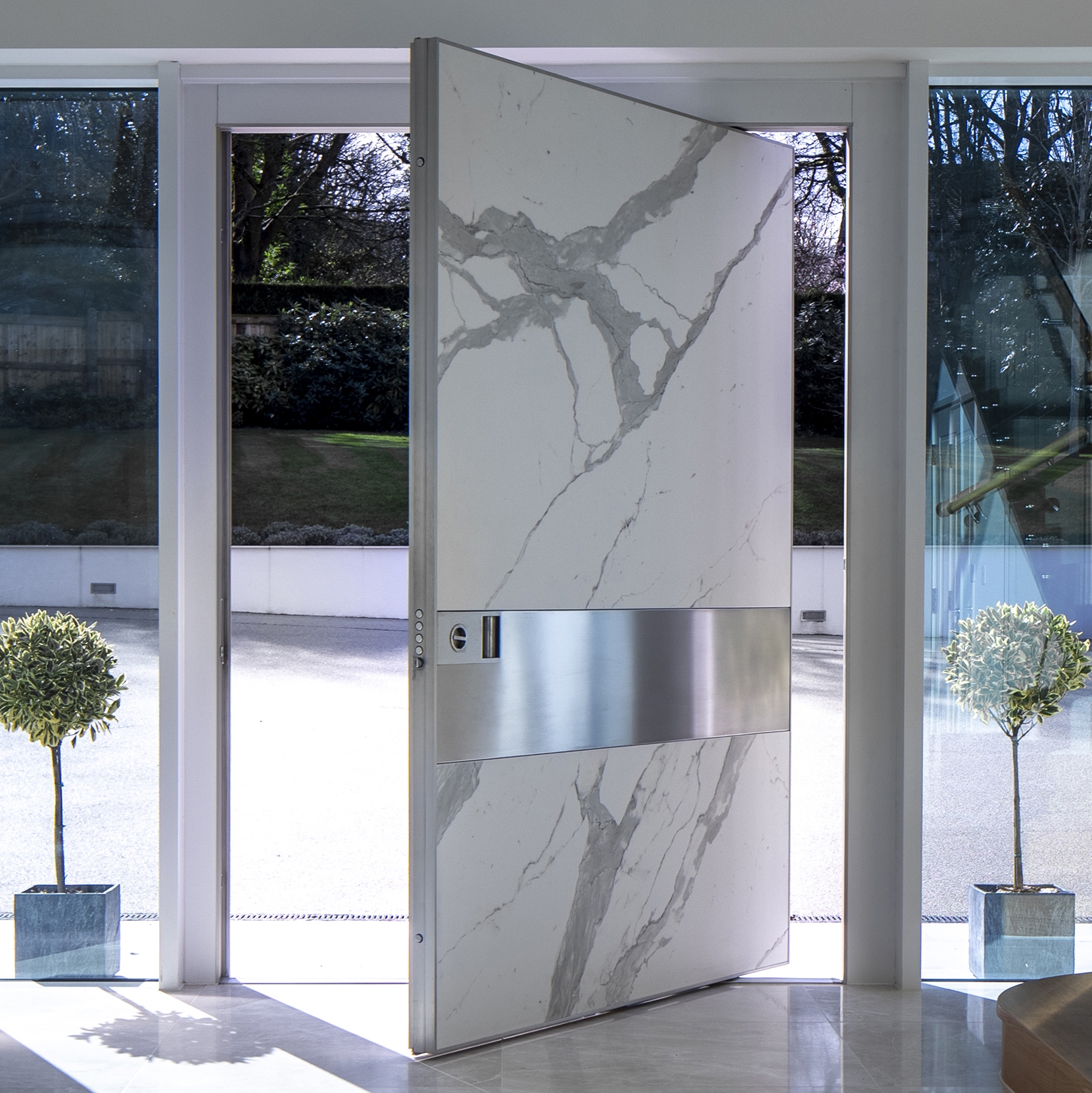 Mostrar el producto Synua | La puerta blindada para las grandes dimensiones, con funcionamiento de pivote vertical y complanar con la pared del fabricante Oikos Venezia – Architetture d’ingresso