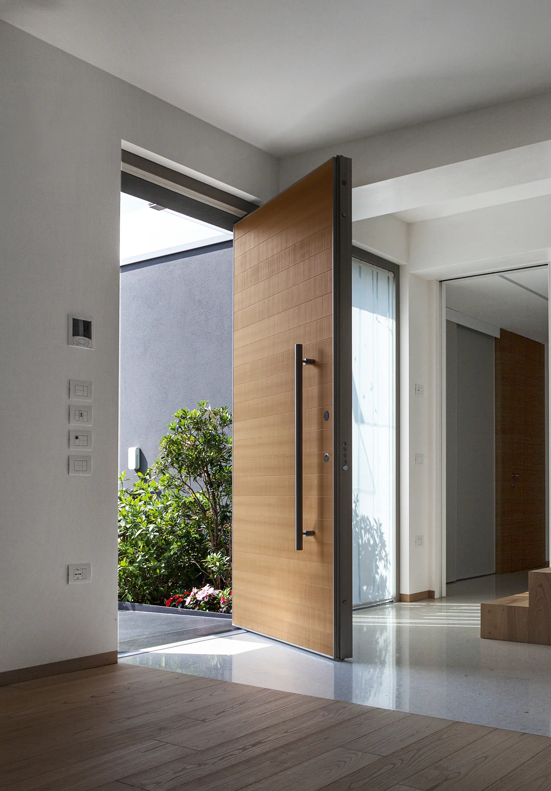 Oikos Venezia – Architetture d’ingresso - Synua | The safety door for large dimensions, with vertical pivot operation and installation coplanar with the wall.