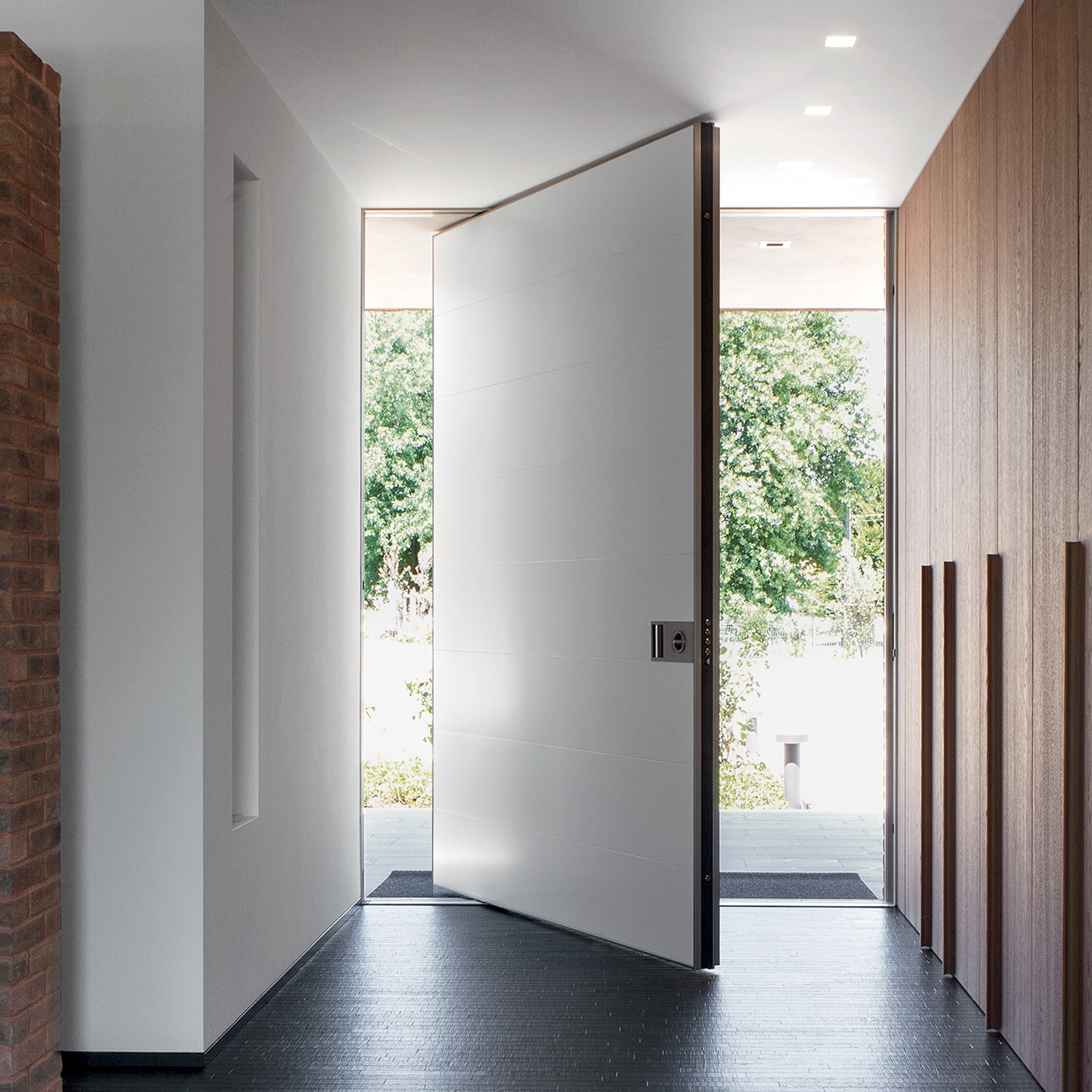 Mostra il prodotto Synua | La porta blindata per le grandi dimensioni con funzionamento a bilico verticale e complanare al muro. del produttore Oikos Venezia – Architetture d’ingresso