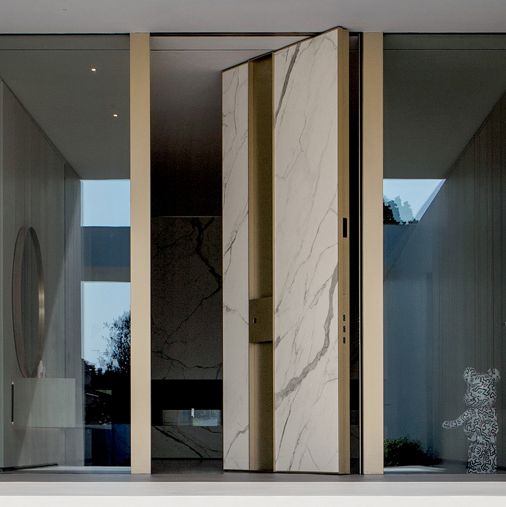 Display product Synua | The safety door for large dimensions, with vertical pivot operation and installation coplanar with the wall. from manufacturer Oikos Venezia – Architetture d’ingresso
