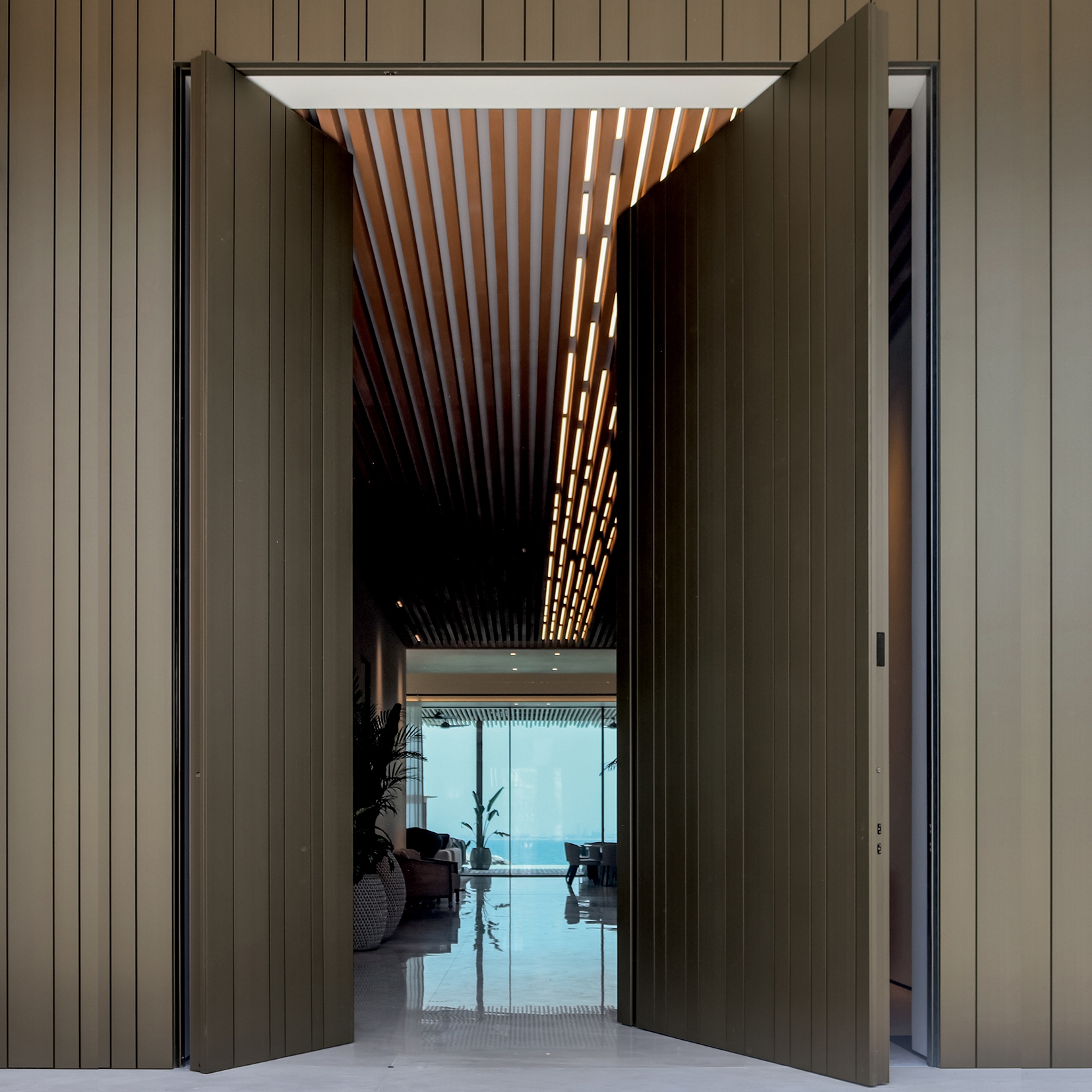 Display product Synua | The safety door for large dimensions, with vertical pivot operation and installation coplanar with the wall. from manufacturer Oikos Venezia – Architetture d’ingresso