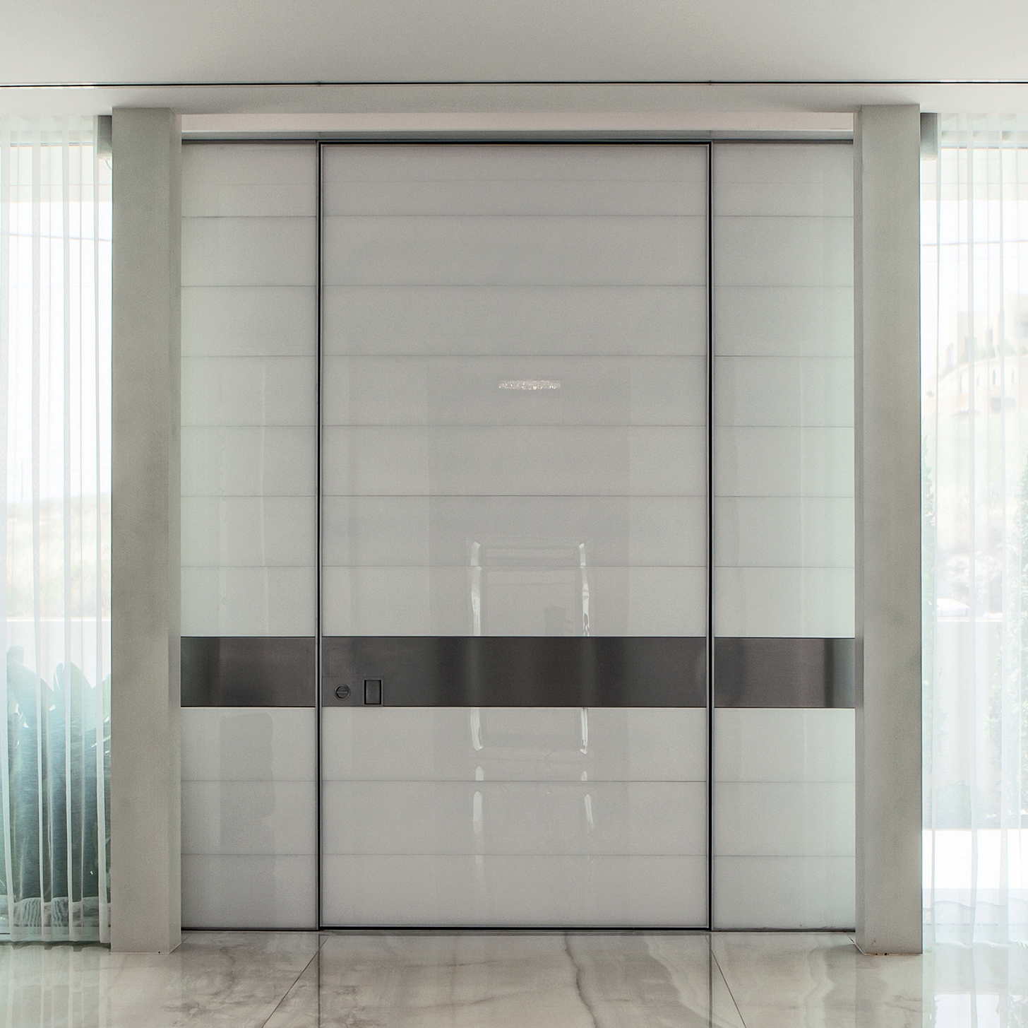 Mostra il prodotto Synua | La porta blindata per le grandi dimensioni con funzionamento a bilico verticale e complanare al muro. del produttore Oikos Venezia – Architetture d’ingresso