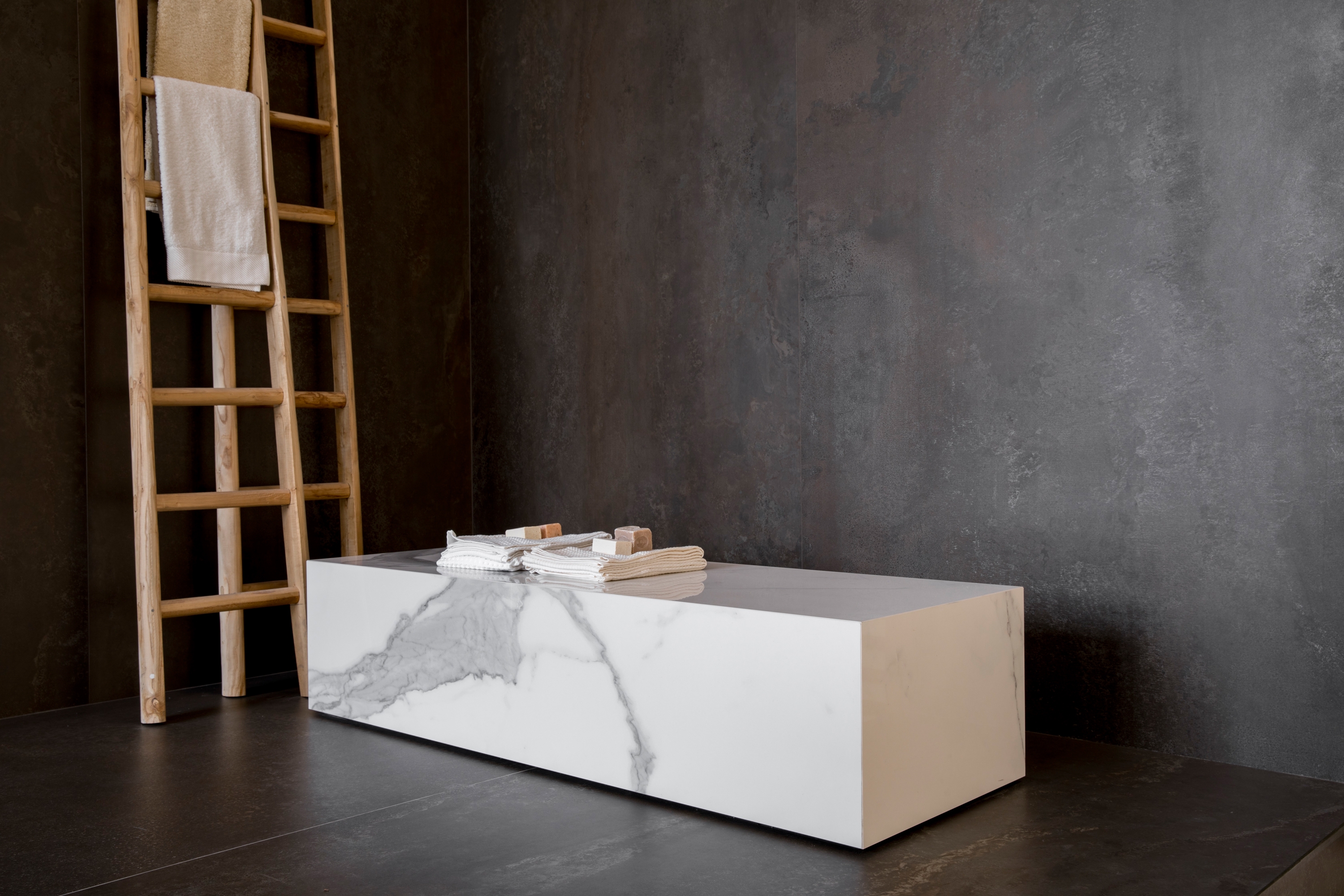 Die grossformatigen Platten eignen sich hervorragend für architektonische Projekte und verleihen Fassaden eine homogene Optik (oben), ebenso wie Wänden, Böden und Arbeitsplatten im Innenbereich (mitte, unten)