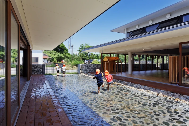 The YM Nursery by HIBINOSEKKEI + Youji no Shiro features large, glazed sliding doors, which not only bring in natural light, but also connect the kindergarten with the nature outside, and with traditional Japanese architecture. Photography: Studio Bauhaus