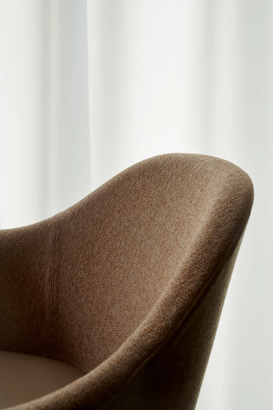 The chair’s solid yet lightweight design features a wooden frame and upholstered shell that cradles and supports the sitter