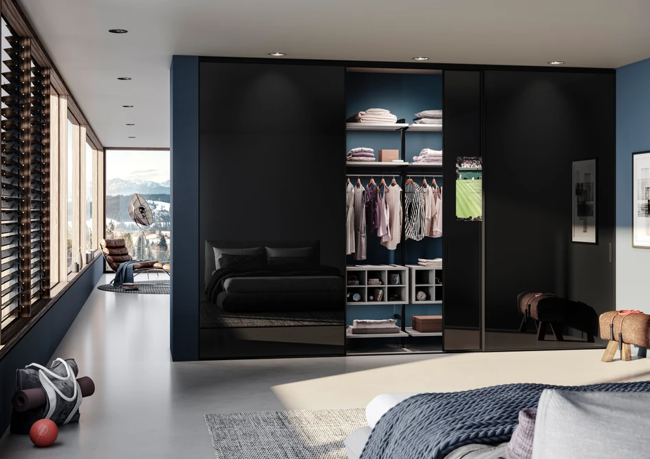  Die superflache TV-Schiebetür von Raumplus mit integriertem Bildschirm stellt sicher. dass die klare architektonische Harmonie nicht gestört wird