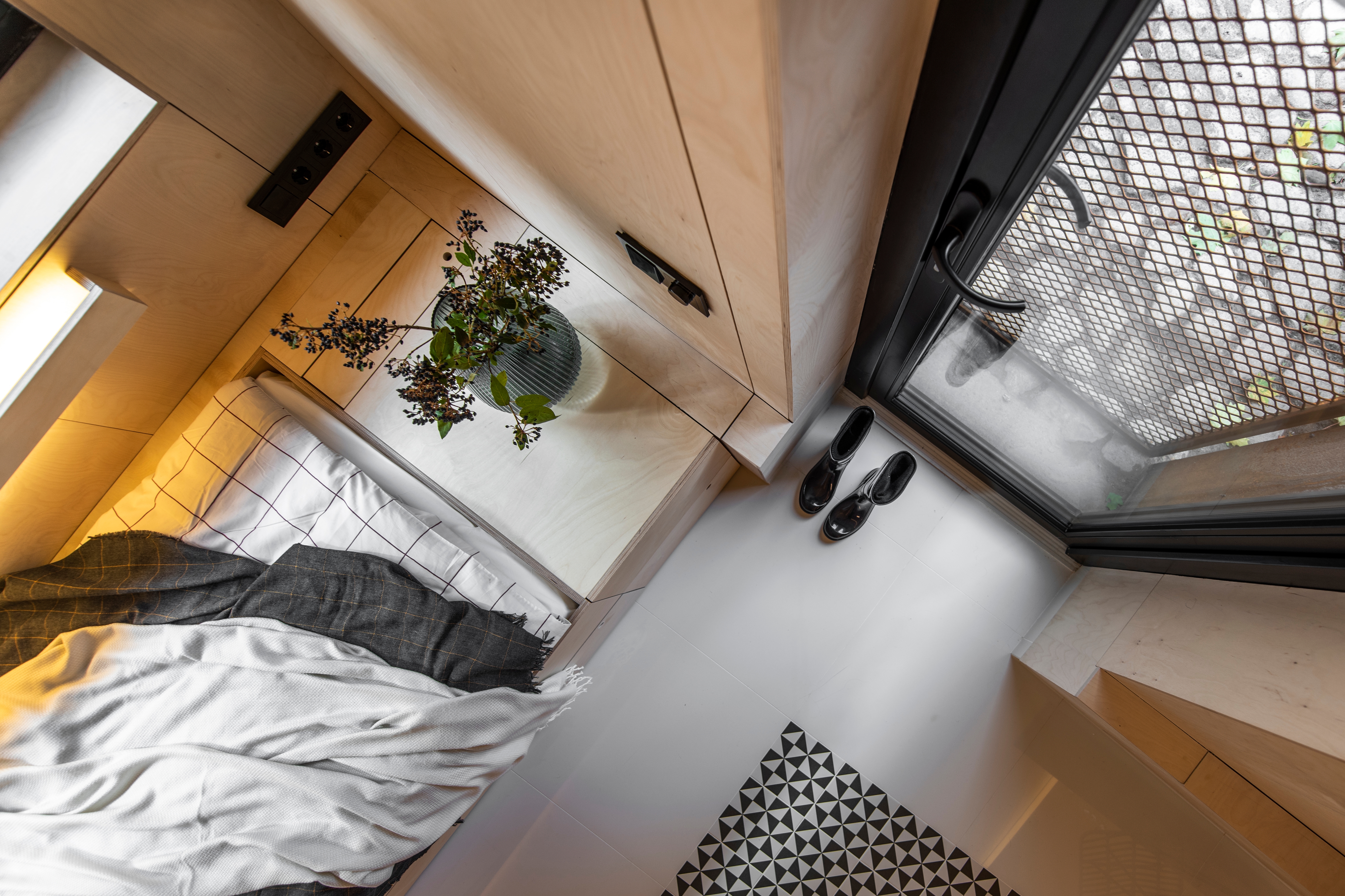 IM Interior's Garage/Studio is a successful micro living conversion in which the architects have managed to create a robust, almost defensive exterior with a warm and welcoming internal space.  Photographer: Leonas Garbačauskas