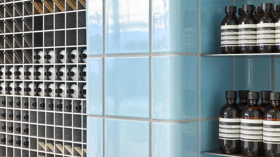 The image of poolside relaxation in the Aesop Century City store in Santa Monica is further reinforced by the inclusion of a large, potted palm tree and a bright yellow reclining lawn chair