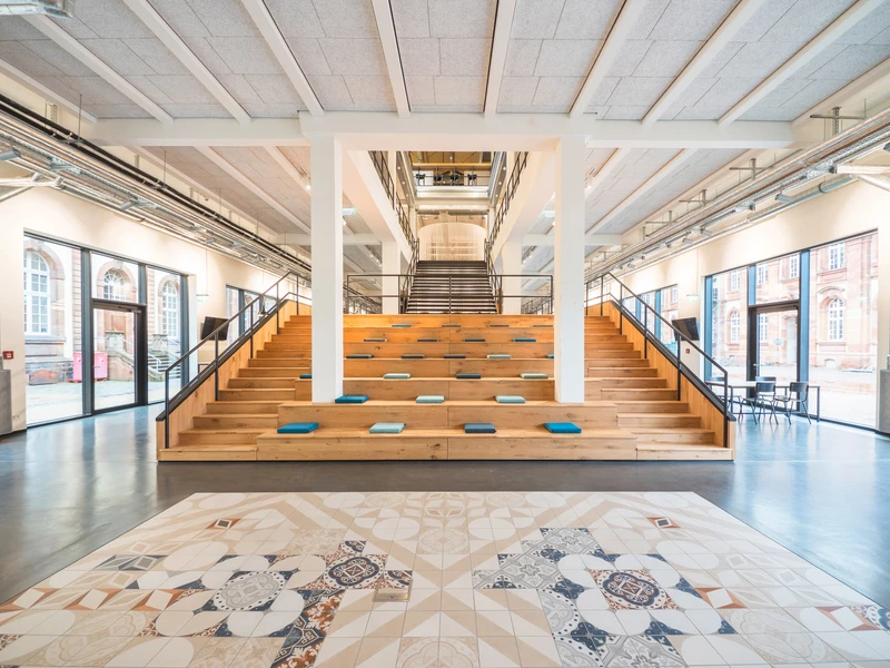 La « Marktplatz » (littéralement la « place du marché ») centrale avec son large escalier en bois invite à s’y attarder et constitue un point de rendez-vous pour les réunions ainsi que pour les soirées football partagées devant le grand écran