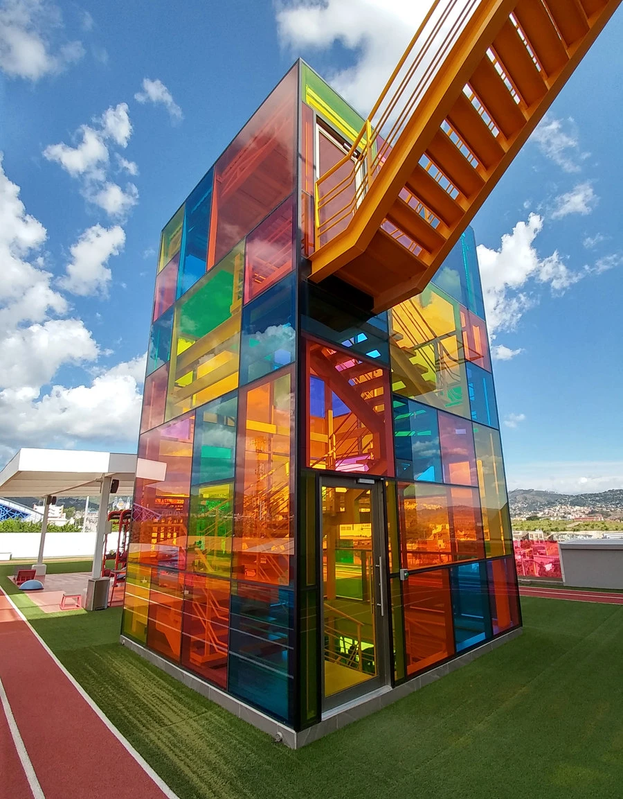 On the rooftop of AJ Fitness in the Honduran capital of Tegucigalpa, coloured panes envelop the stairwell tower and also surround the outer perimeter of the running track