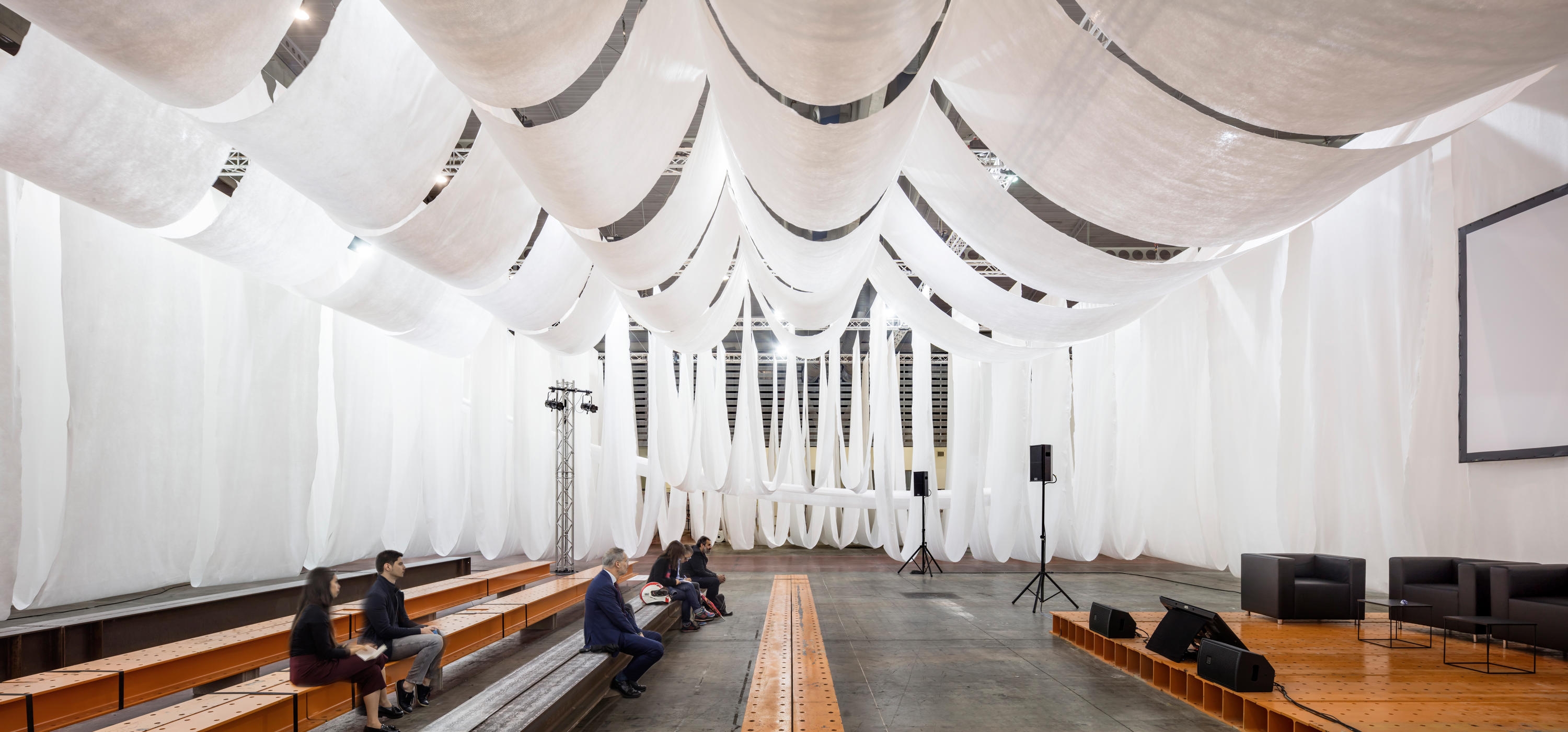 The interplay of heavy steel and light textiles in Josep Ferrando Architecture's Barcelona Building Construmat Ephemeral Space also aims to showcase the interplay of permanent and temporary components used during building construction. Photos: Adrià Goula