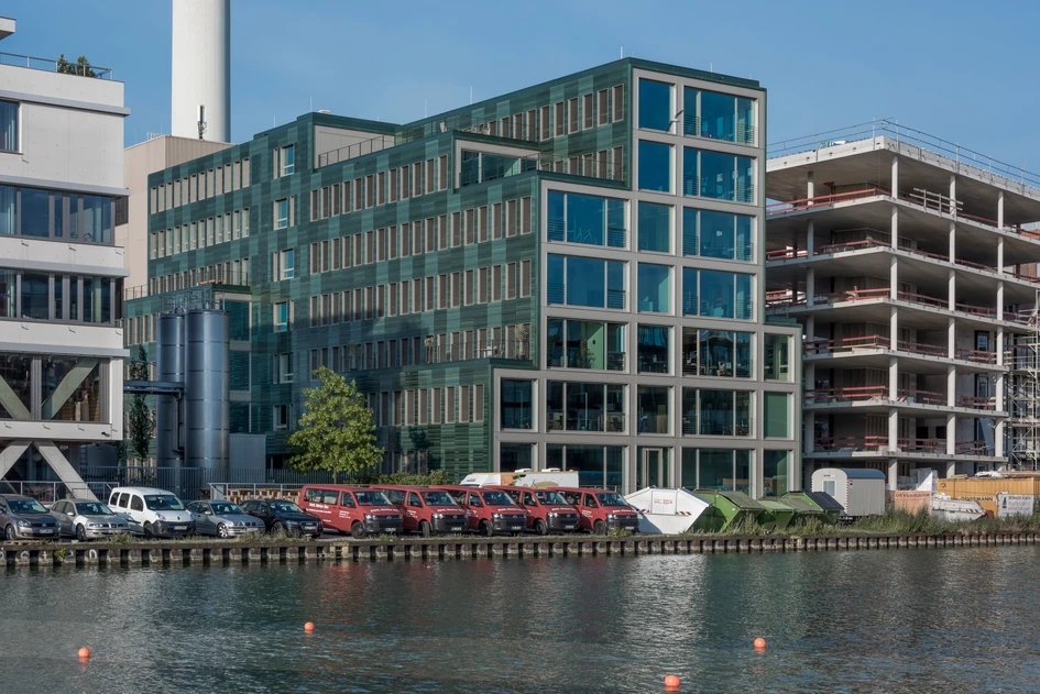 Tone on tone with the water: The facade of the timber hybrid H7 building in Münster highlights the elegance of the architecture with its green, glazed ceramic tiles and fine horizontal relief structure. Photos: Anke Müllerklein