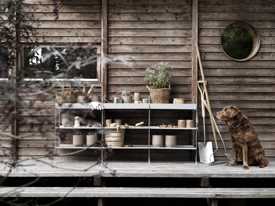 Robust, steel-coated alu-zinc meets soft dog coat at String Furniture's photo shoot for its new, weather-resistant outdoor shelving family, based on Nils Strinning's classic design