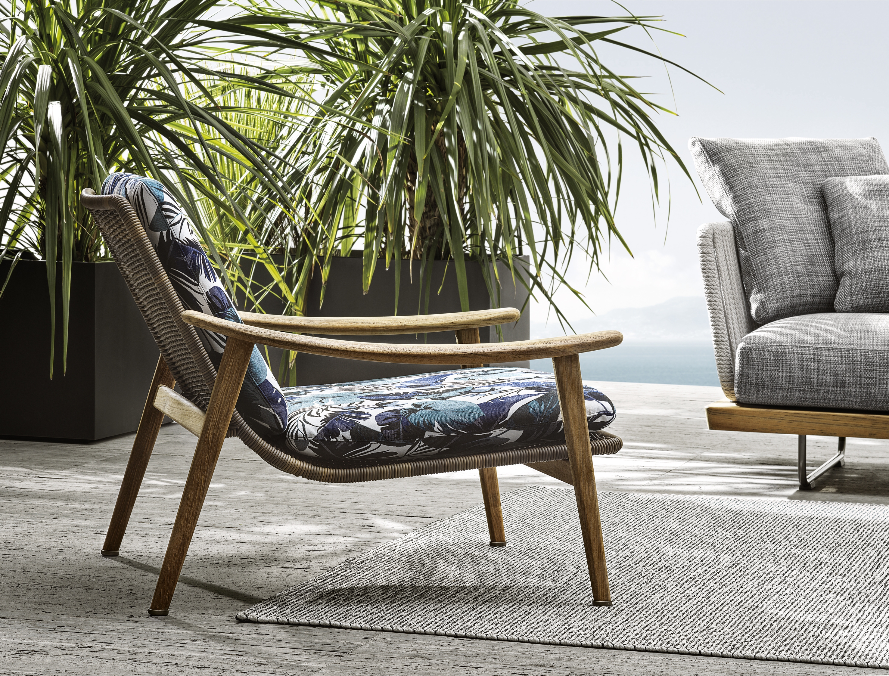 Top: GamFratesi’s Fynn dining table has curved corners that echo the armchairs’ curvilinear armrests. Above: A Fynn armchair upholstered with an on-trend tropical print 
