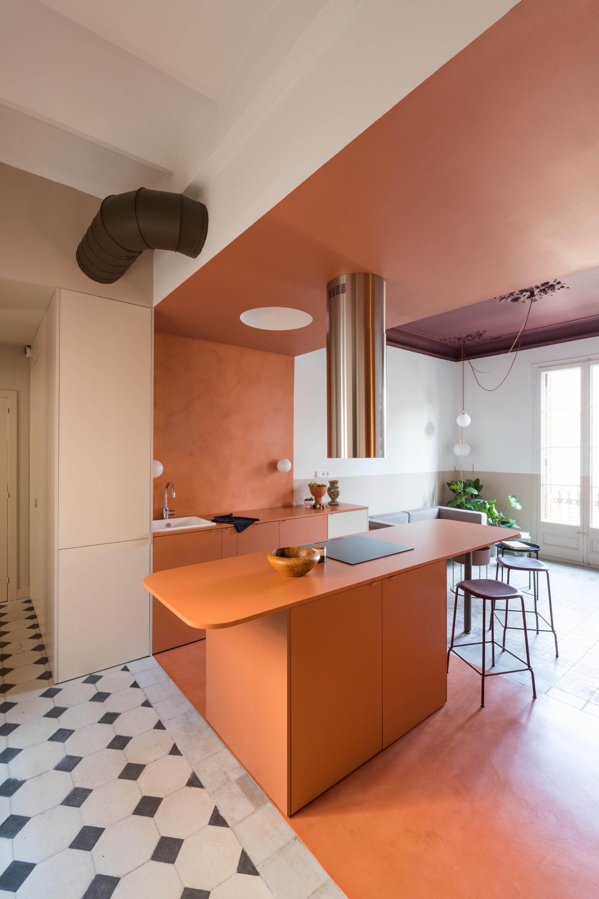 In the Klinker Apartment in Barcelona, designed by CaSA – Colombo and Serboli Architecture, a wide terracotta-coloured band delineates the kitchen and a small adjacent office nook. Photo: Roberto Ruiz