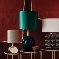 Top: Porta Romana’s Cocoon and Orb pendant lights above the Large Miro Centre table with a French brass base and dark fumed oak top. Above, from left to right: Sway, Bishop and Boublé lamps on the Lilypad nest of tables