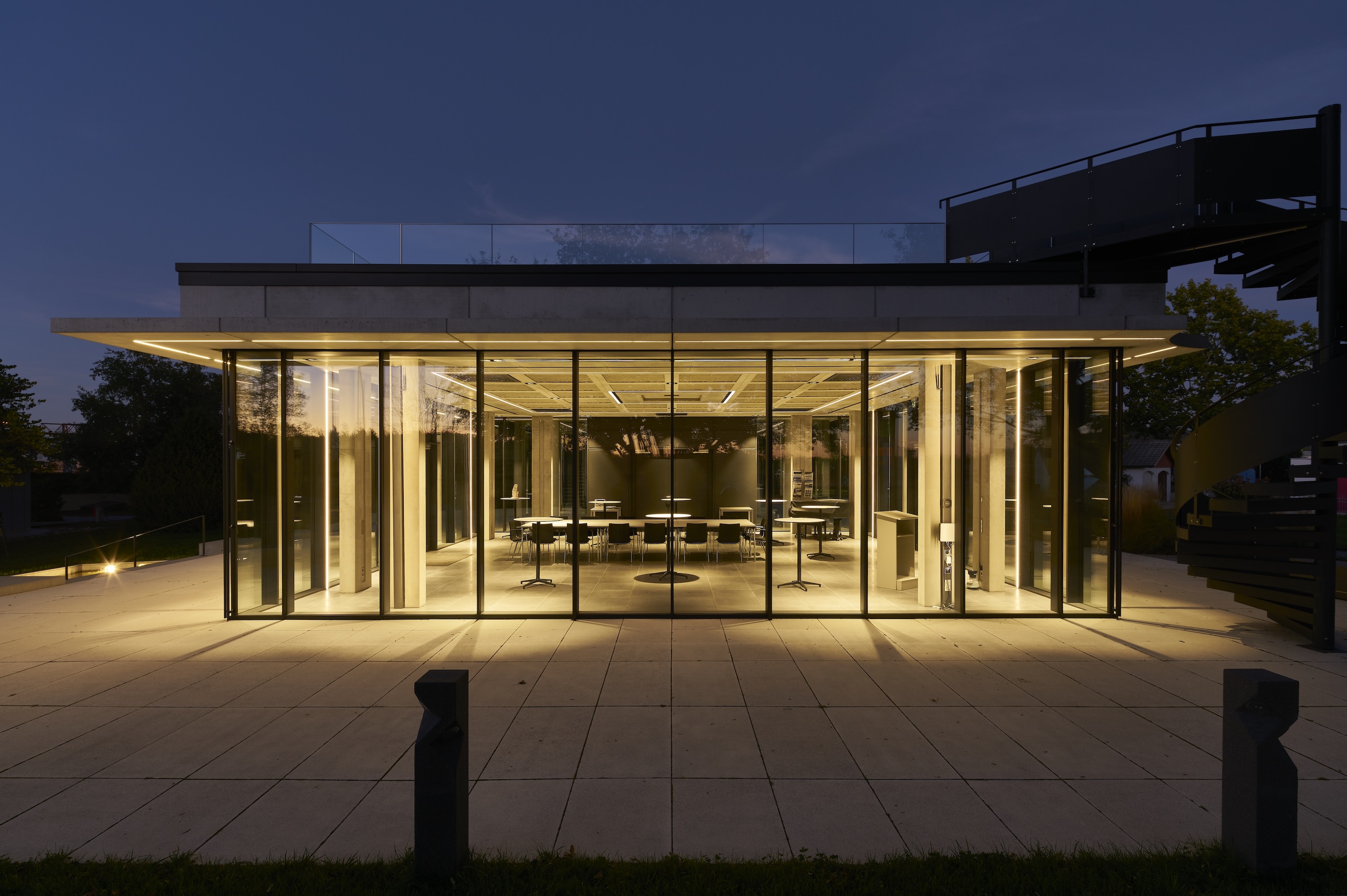 Tagsüber profitiert man Innen vom ultimativen Lichteinfall, nachts strahlt die Architektur dank des Panorama Design Fassadensystems von Schüco selbst sehr imposant im Ausstellungspark von Birkenmeier Design + Stein