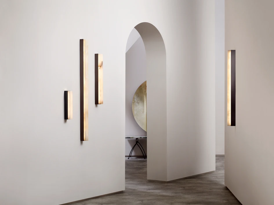 The Artés collection lights are composed with striking architectural beams made of bronze, satin brass and honed alabaster