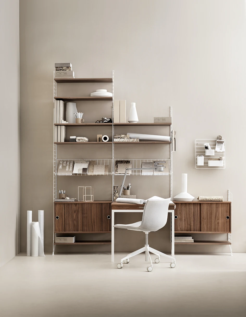 Top: The sit-stand desk hides its periscope in a central leg. Above: The String Shelf was designed in 1949, but it’s still perfect for working in 2020