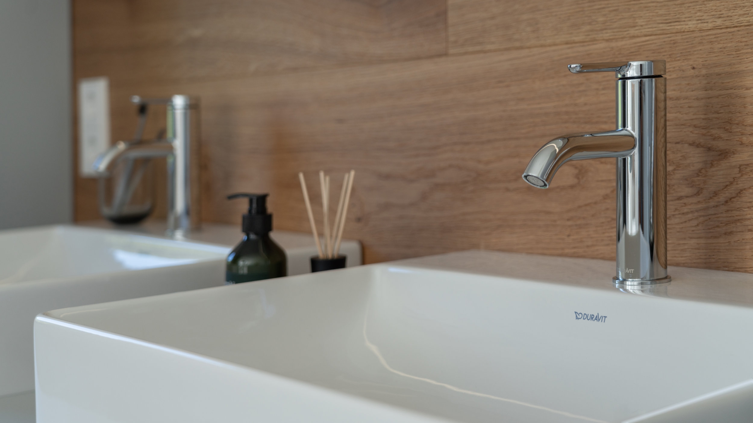 Before and after: the comparison dramatically shows the modern, timeless quality of Duravit’s bathroom design – as here with the DuraSquare washbasins in combination with Brioso bathroom furniture