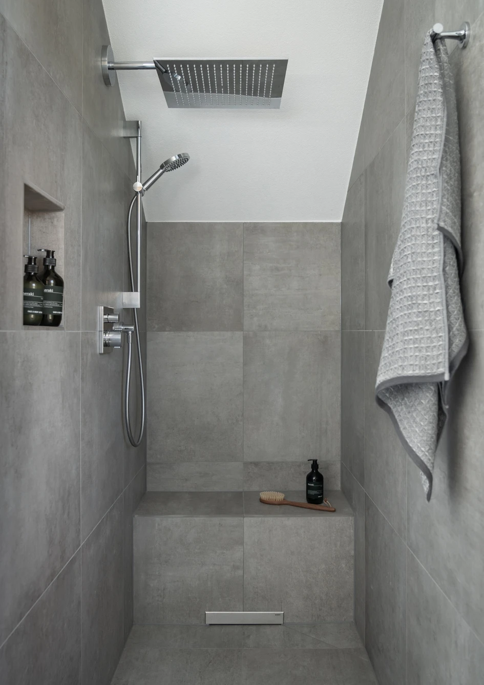 The mirror with dimmable LED lighting visually enlarges the room, which, thanks to partitions has more structure. The floor-level shower offers easy access and comfort with underfloor heating, square overhead shower and hand shower
