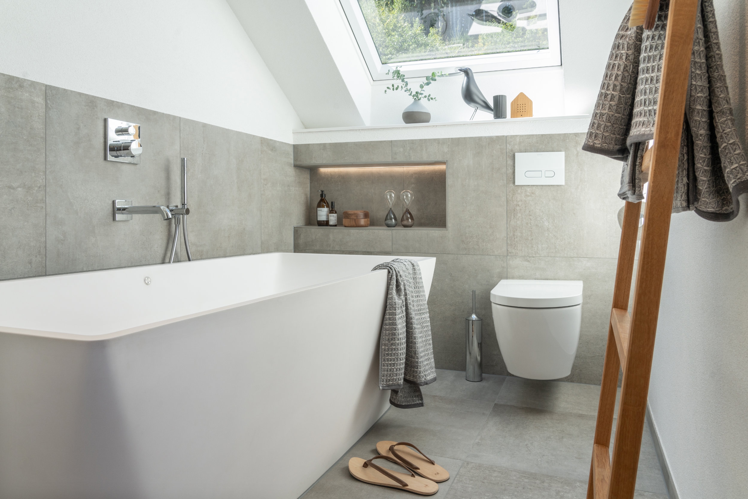 The freestanding bathtub with two back slopes and integrated air-whirlpool system is not only eye-catching, it is also a place for relaxation that the whole family can enjoy