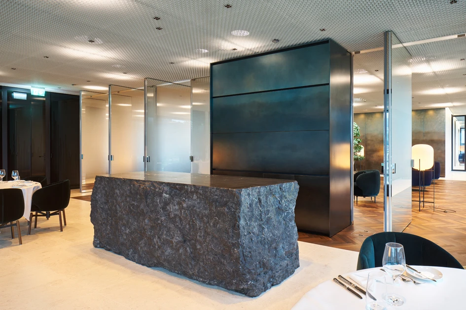 A partially mirrored, smoked-glass wall – made up of pivoting panels – allows the creation of a more expansive interior volume, if required, and increased circulation and longer sightlines