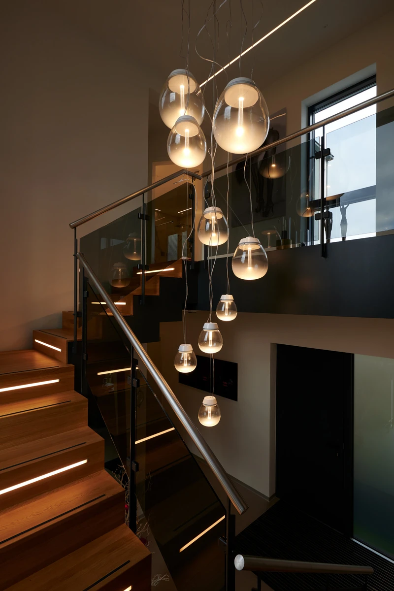 With lightness and transparency, a cluster of Empatia luminaires by Artemide connects the two floors – the more sociable living area below with the private part above