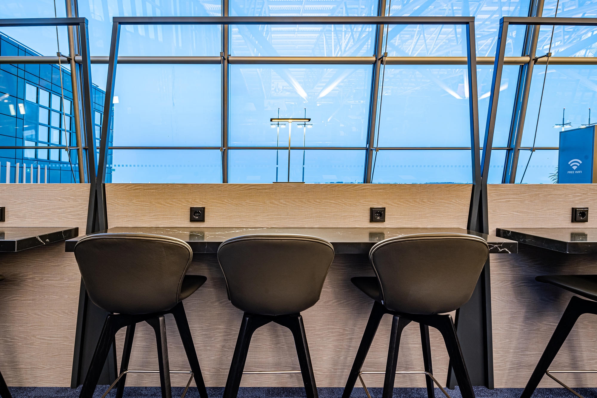 The lounge is divided into zones that allow for different activities, from casual idling in armchairs, to drinking at bar tables, meeting in comfort, to working at desks complete with charging points