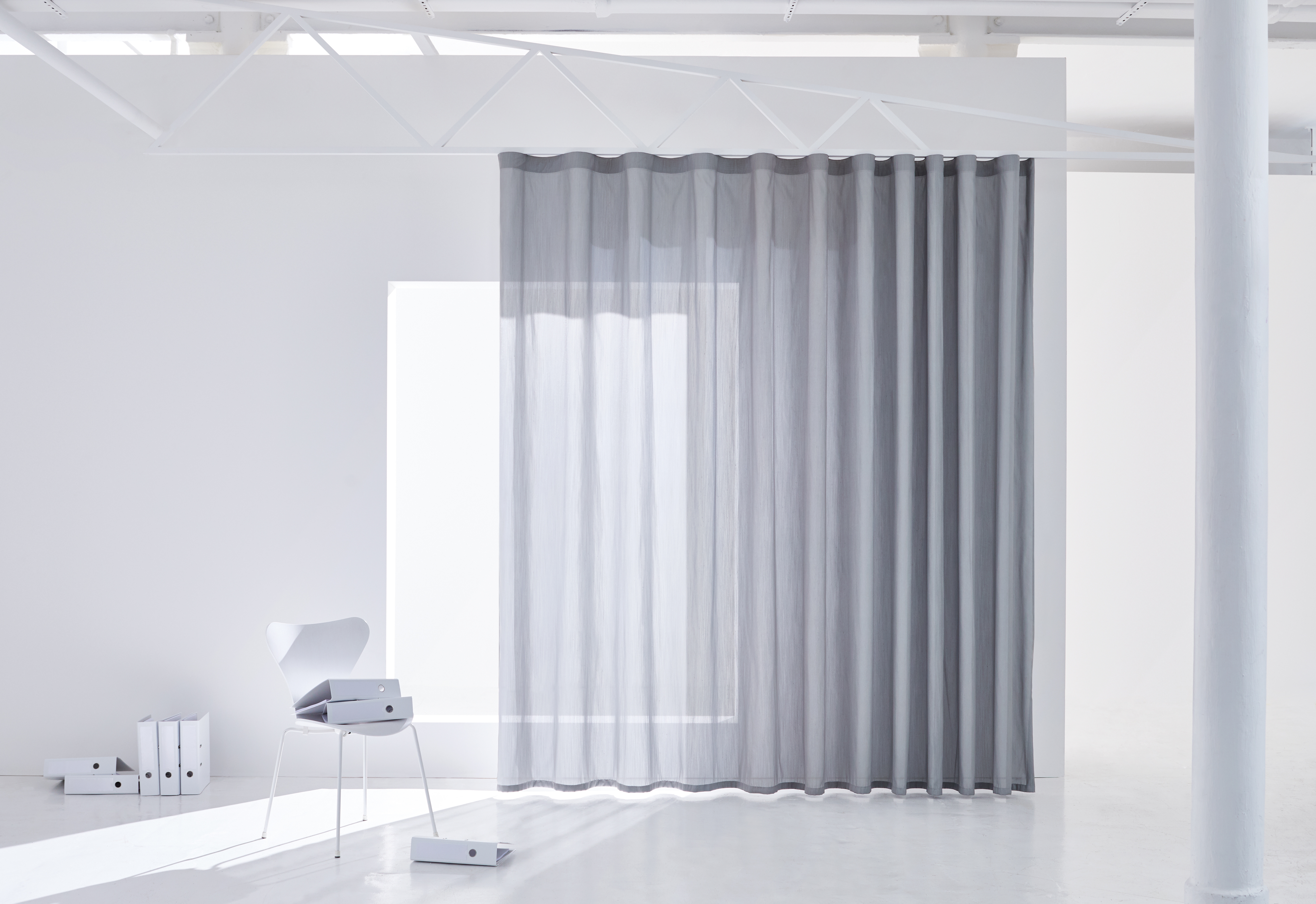 Whether in the office or home office, the more natural daylight, the better it is for the mind. Curtains from the GLARE & HEAT collection by Création Baumann protect against glare as well as  heat from direct sunlight