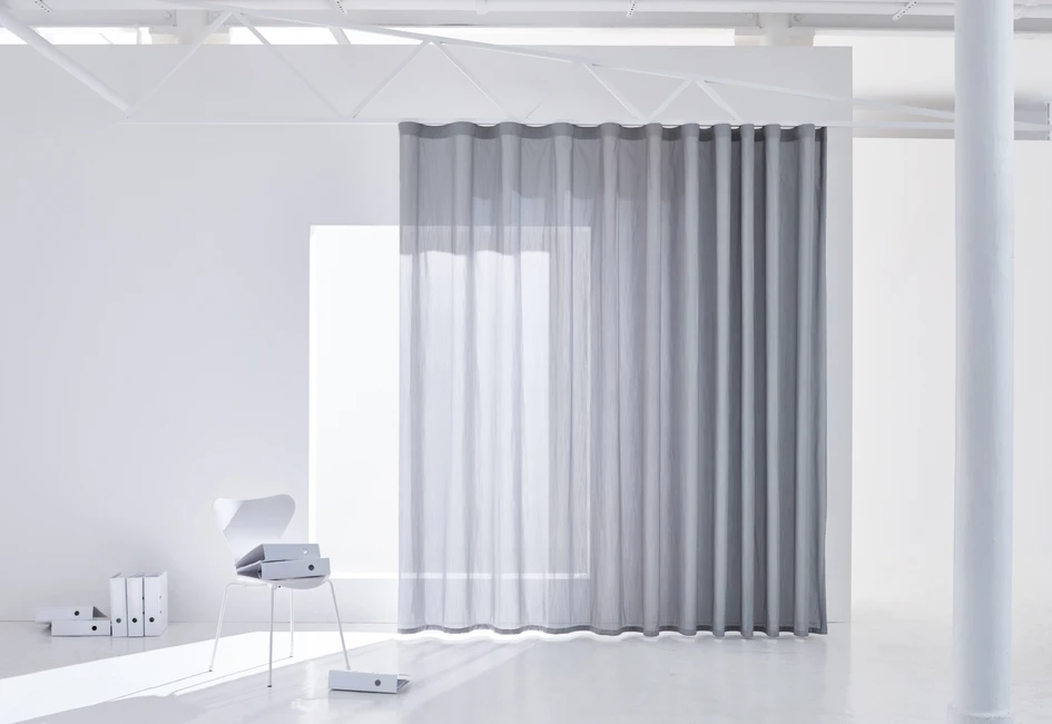 Whether in the office or home office, the more natural daylight, the better it is for the mind. Curtains from the GLARE & HEAT collection by Création Baumann protect against glare as well as  heat from direct sunlight