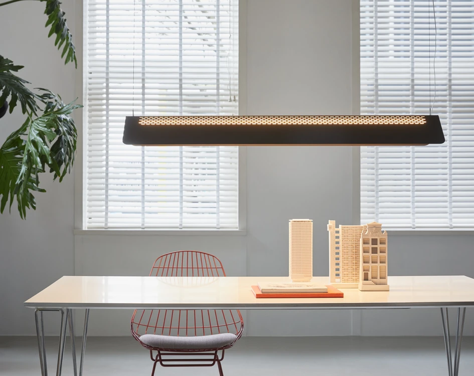 Ernst Koning’s Flybye light lowers a warm, direct light gently down onto a table’s surface. While perforations in its powder-coated steel shade add no more than a soft, accompanying glow to the room