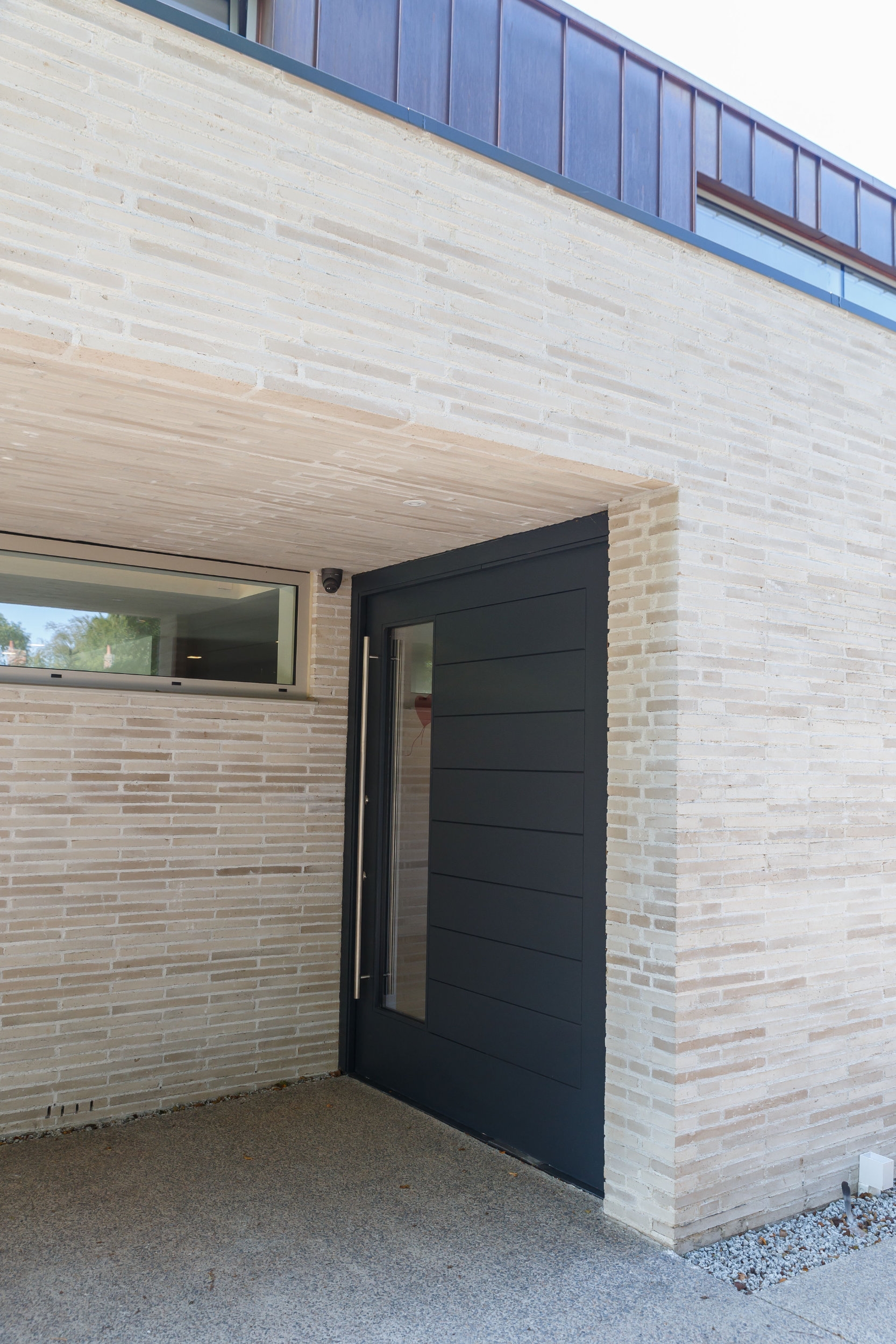 Continuing across and under the extended canopy of this Warwickshire home in the UK, RT 154 Ultima brickwork naturally leads visitors and residents inside