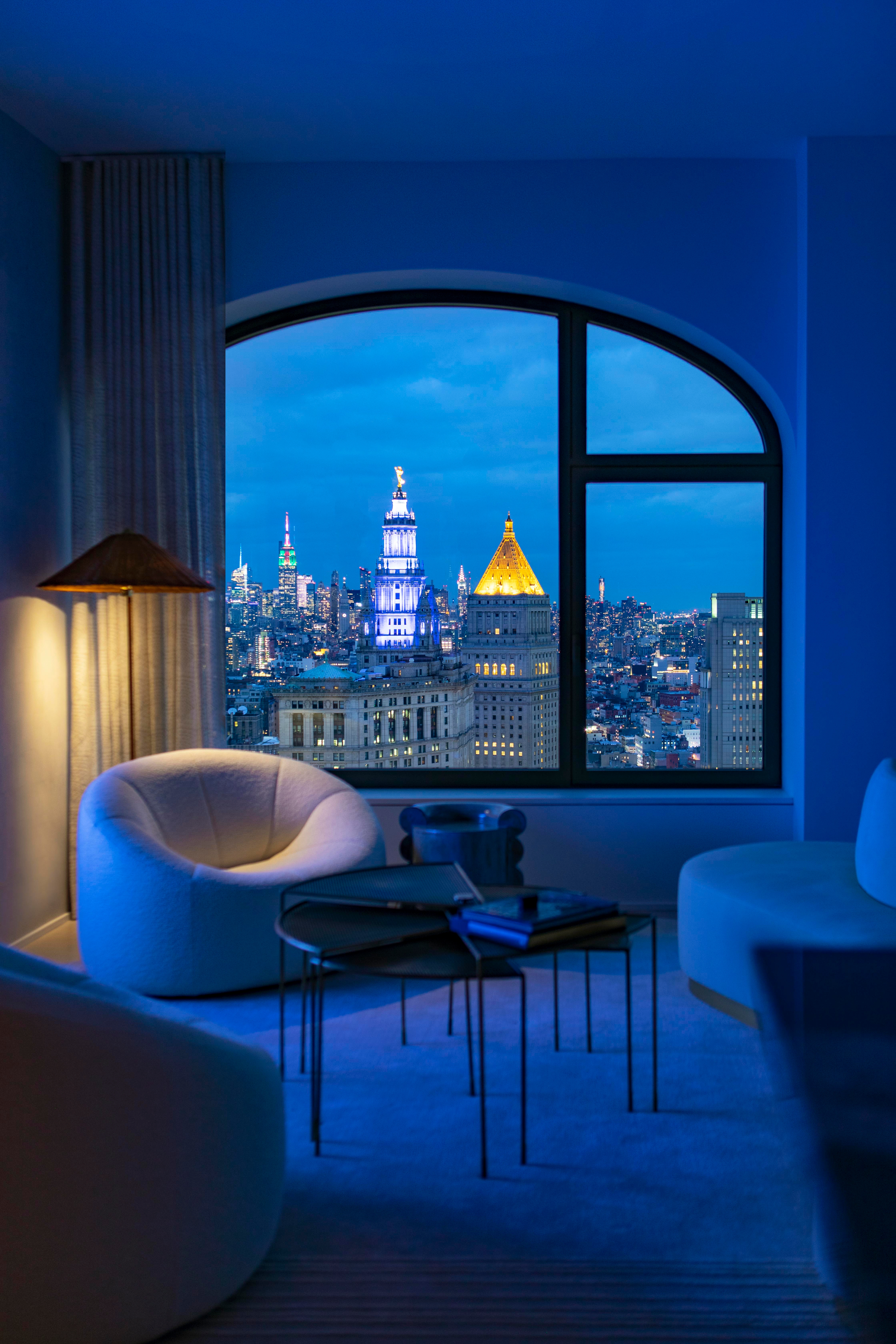 Sanctuary provided by Pierre Paulin’s Pumpkin lounge chair and a fanned, oxidised-brass coffee table, alongside breathtaking views across Manhattan through one of the over-sized arched windows