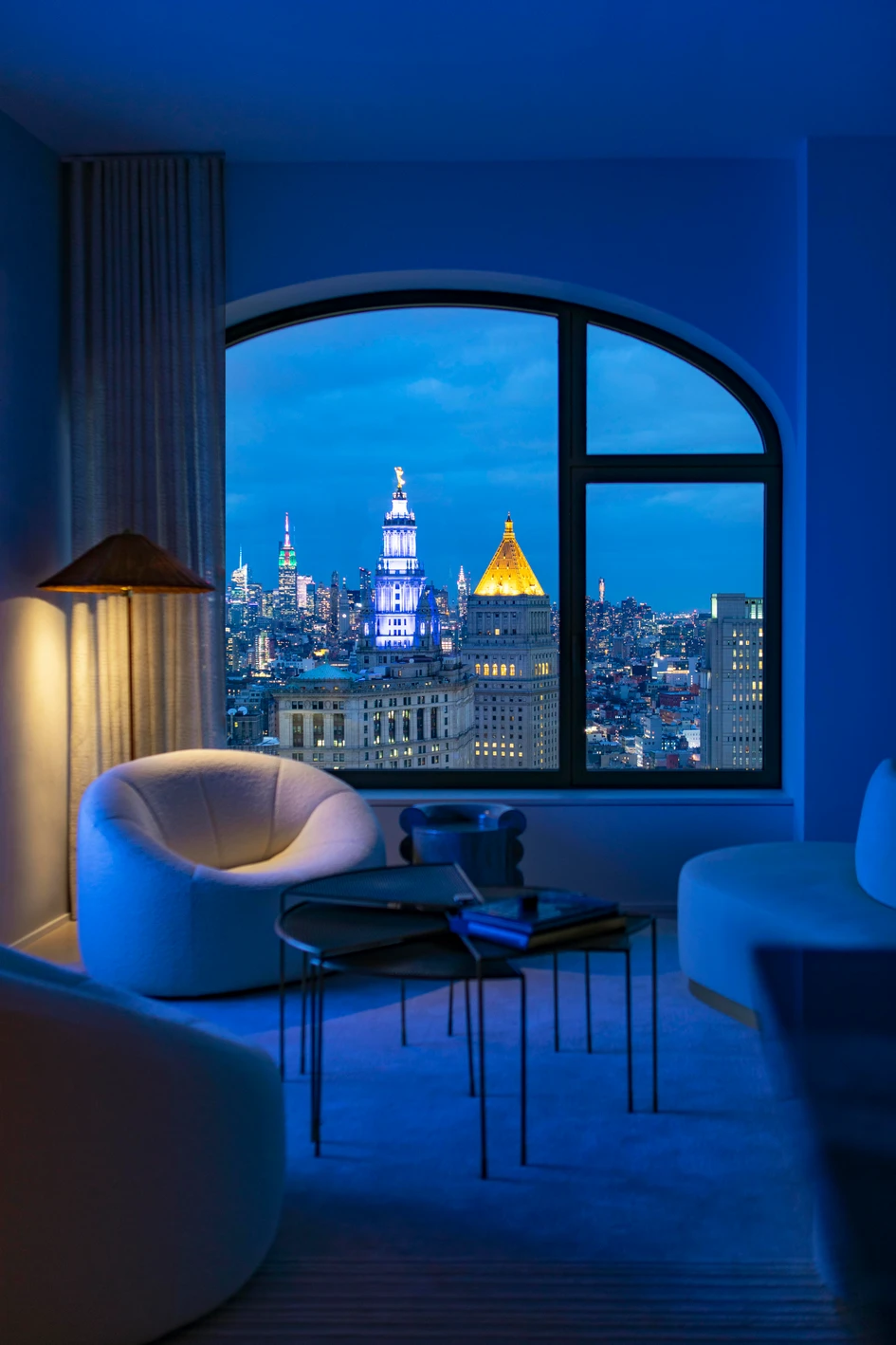 Sanctuary provided by Pierre Paulin’s Pumpkin lounge chair and a fanned, oxidised-brass coffee table, alongside breathtaking views across Manhattan through one of the over-sized arched windows