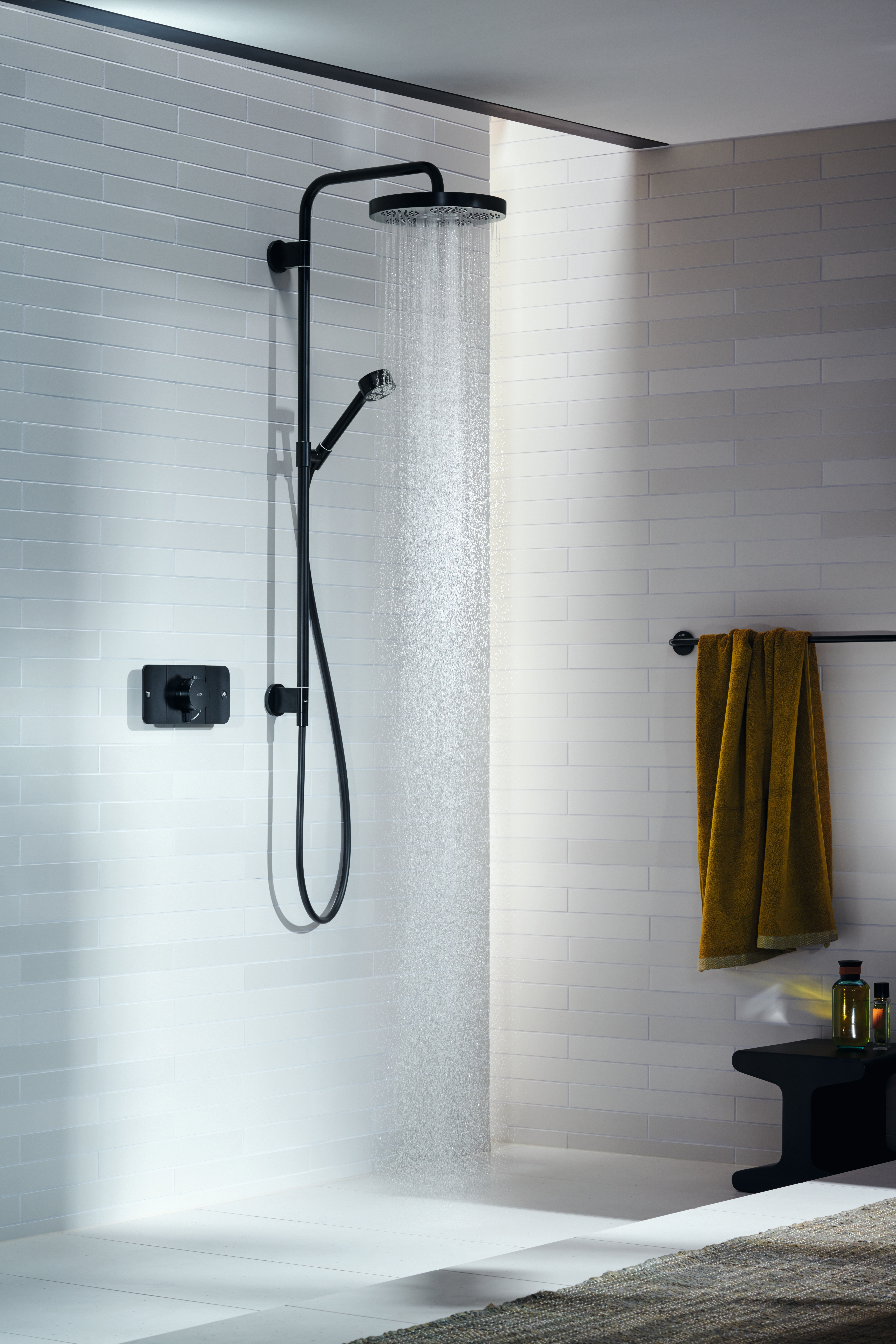 Water at the touch of a button: both the basin mixer and the shower mixer can be operated by push movement. The water temperature is regulated by an intuitive twist of the lever. Pictured below, the AXOR One Showerpipe