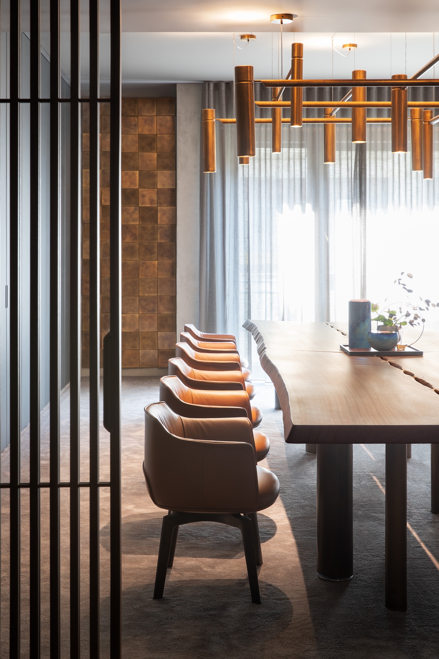 Here, the Exteta Joint table and Henge Tubular Horizontal light by Massimo Castagna, Poltrona Frau’s Archibald dining chairs by Jean-Marie Massaud, Rimadesio’s Sail door by Giuseppe Bavuso, a vase by Anna Torfs and De Castelli’s surface Square 50