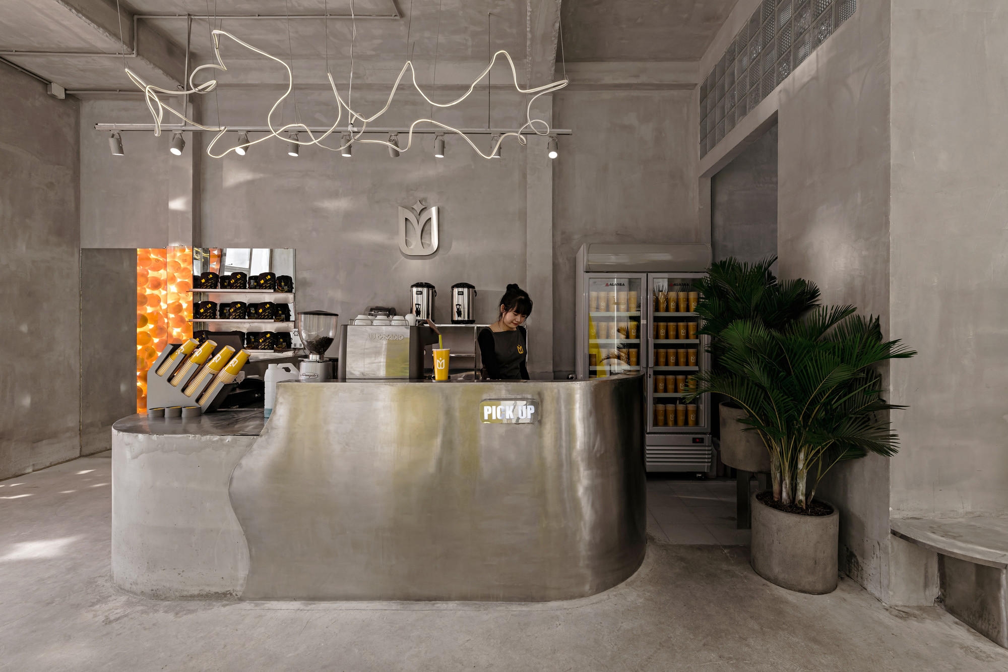 YAMA Coffee Shop's concrete interiors, designed by KSOUL Studio feature exposed concrete walls and delicate furniture meaning the background becomes the space's defining feature. Photos: Valor Studio