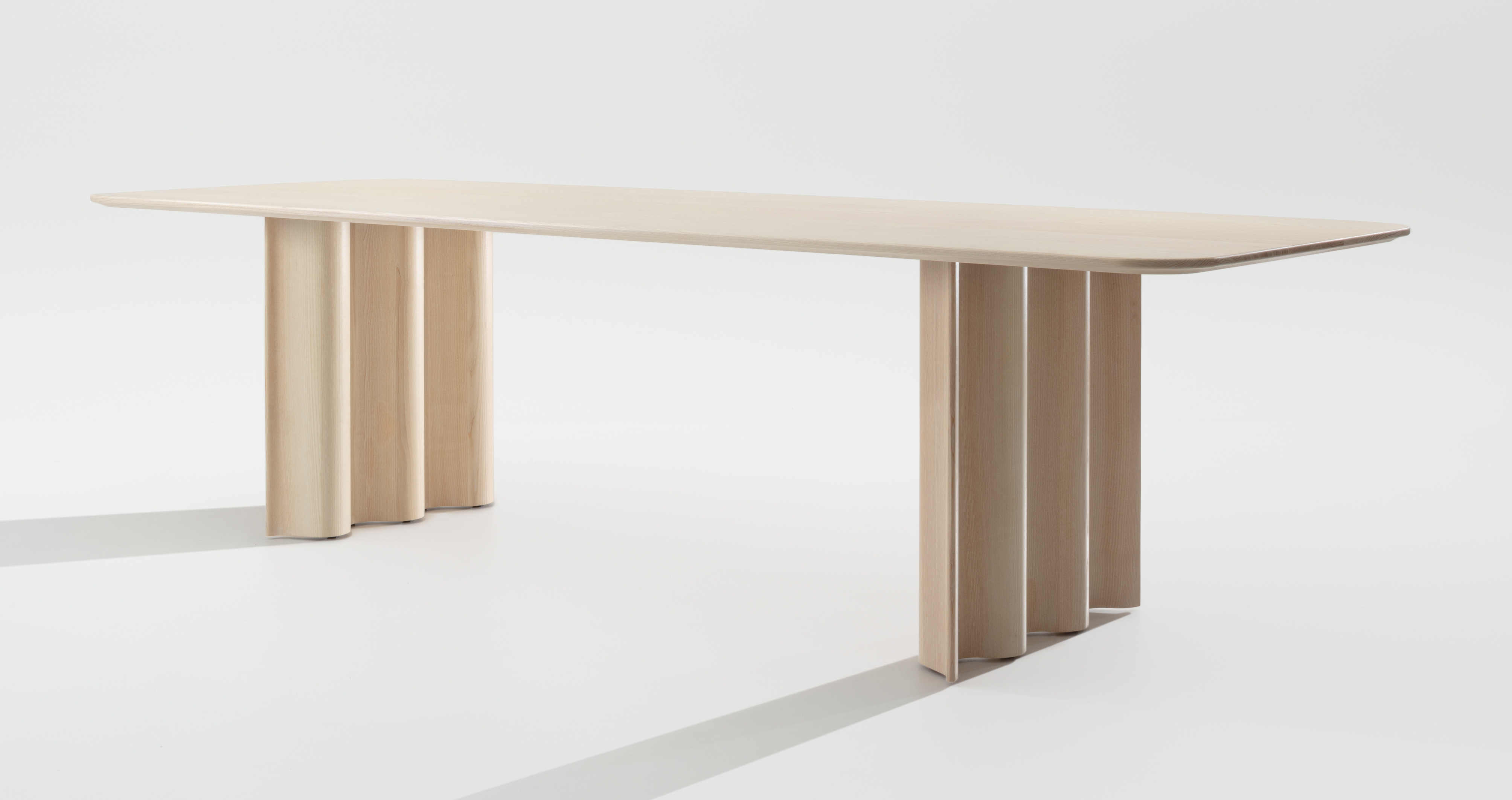 Die Tischplatten aus Massivholz weisen eine schlanke Plattenstärke von 27 Millimetern auf und können in Esche, Nussbaum, Kirsche oder Eiche mit einem durchlaufenden Holzbild gefertigt werden