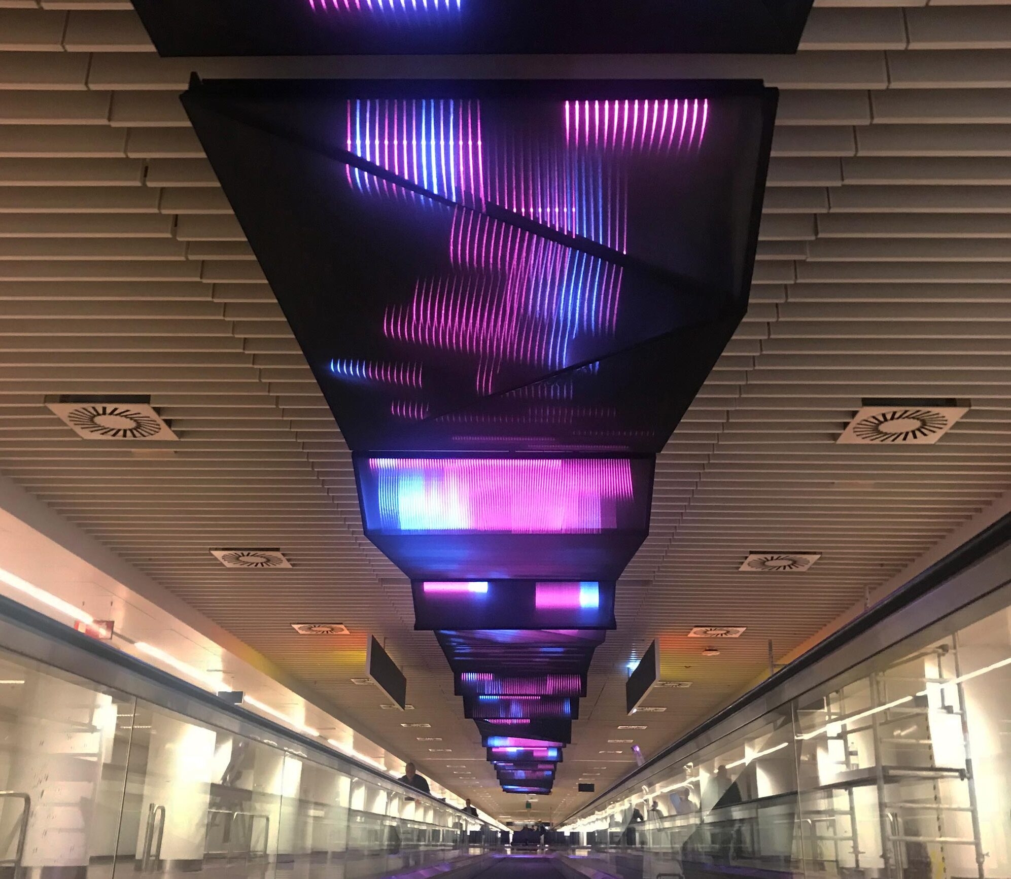 Lighting textiles from Ettlin Lux can be found, for example, in the Brussels airport building: there, ceilings were clad with black Decolux textiles, which have the appearance of a coloured luminous sheet of light. © ACTLD