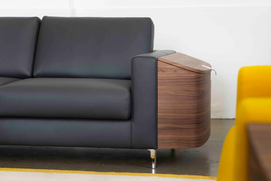 The Saddlebags sofas' armrests are adorned with walnut compartments. With storage space for any object lying around, the features also bring a cosy an enveloping feel to a living room