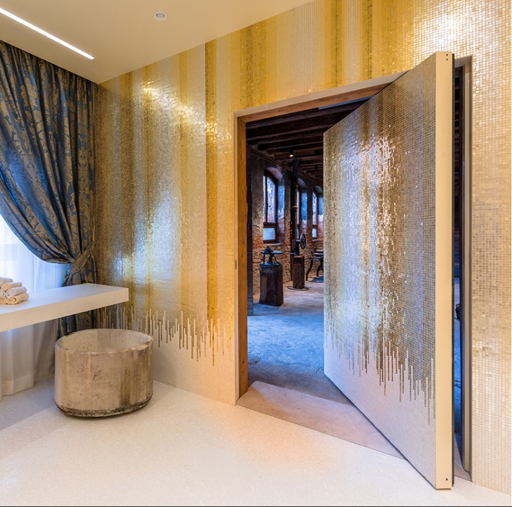 The Orsoni Furnace guest room makes an uninterrupted feature of the historic brand's mosaic tiles, with invisible doors