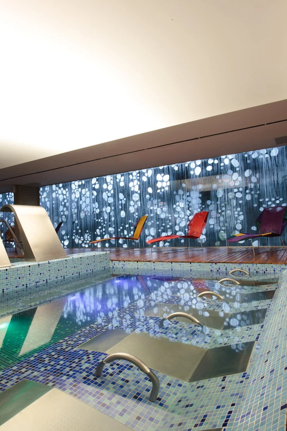 Bogotá's Spa Chairama combines glass with patterned laser-cut metal for a facade that doubles as an intricate interior wallcovering. Photos: Sergio Gomez