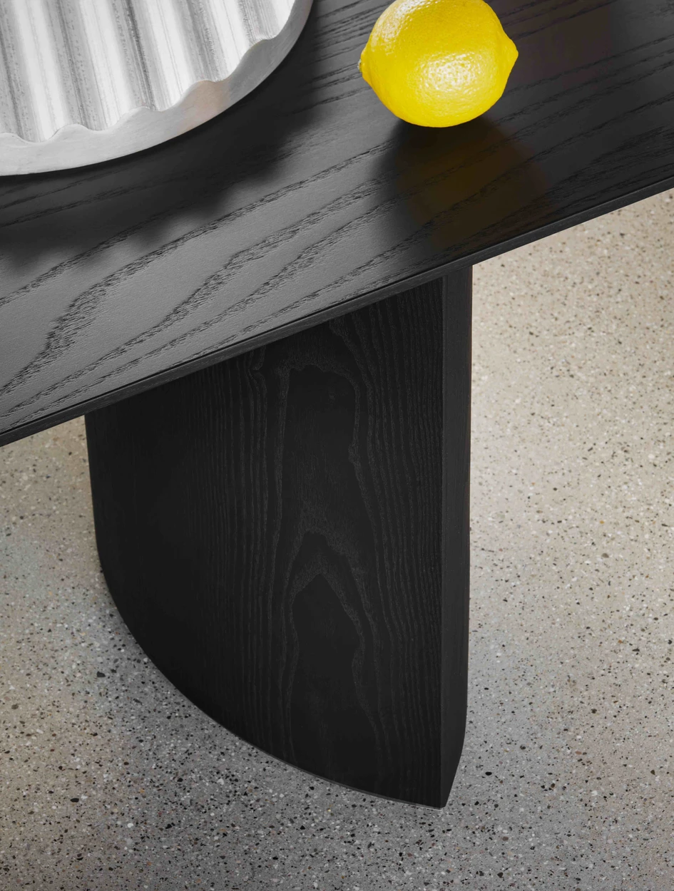 Top: A Detail of Plauto in graphic black ash. Above: The sculptural table fuses arcs and straight lines
