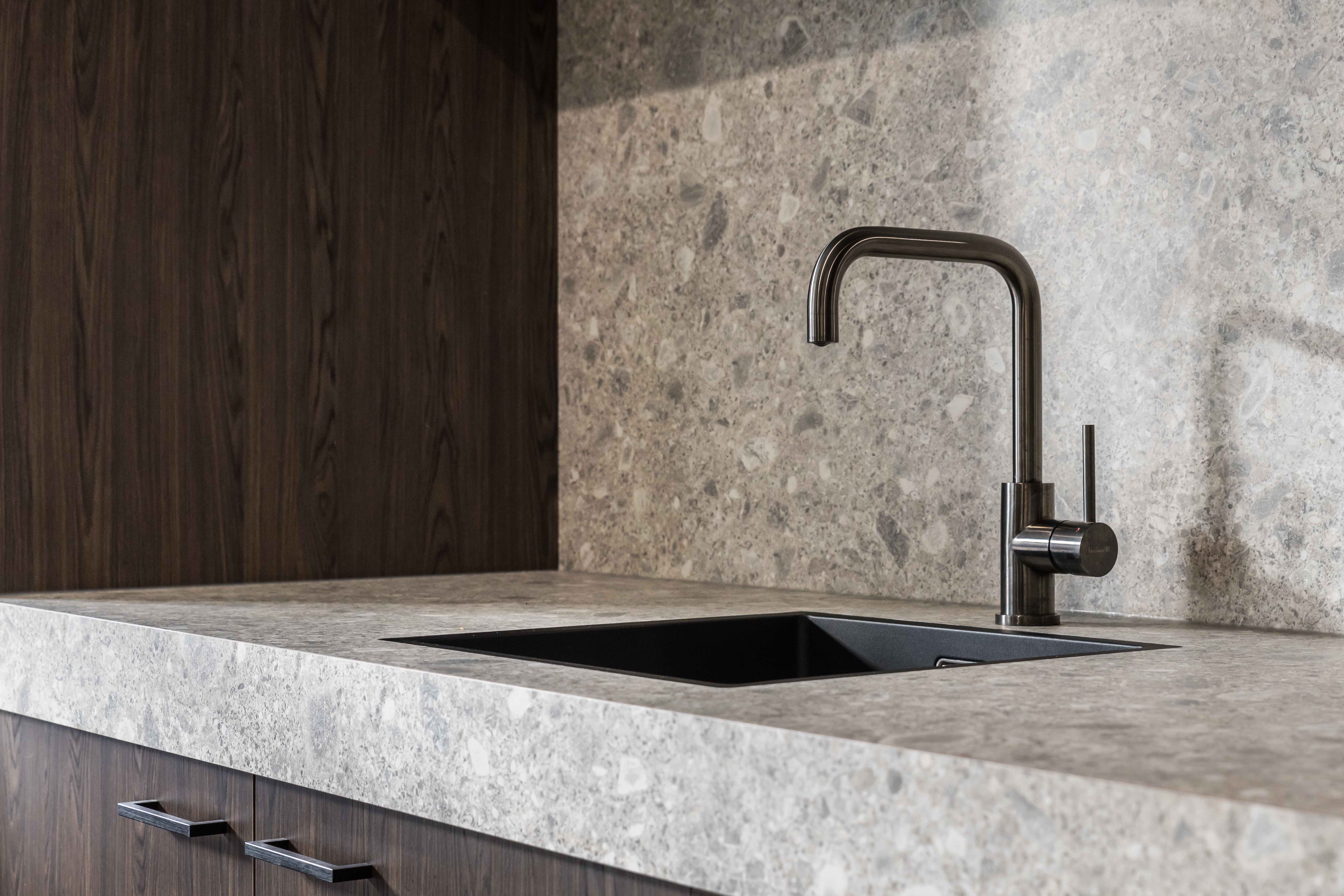 The kitchen worktop is made with Unilin’s Ceppo Mineral, which has an authentic stone-like finish. It blends masterfully with the chocolatey oak finish of the vertical planes