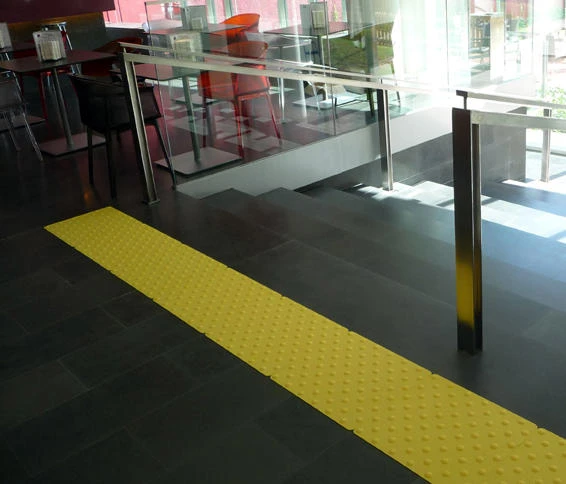 Die Ecolegno-Terrassendielen aus Verbundholz von Saimex (oben) bieten eine Auswahl an Farben, Oberflächen, Maserungen und Rillen, während die ultra-taktilen Podoalerte-Fliesen von Marcal Signalétique die Sicherheit verbessern (unten)