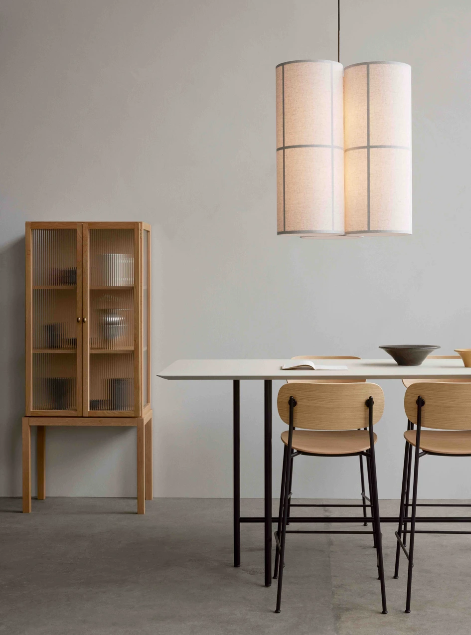 The Co counter chair, pictured here with the Snaregade counter table, the Curiosity cabinet, and the Hashira pendant cluster