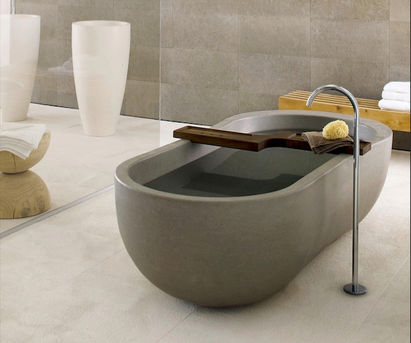 Slipper and dipped tubs like Big Zinc (top) from Kenny & Mason have more back support, while disconnected floor standing taps, like the one flowing into Neutra’s Alone bath (bottom), free up movement