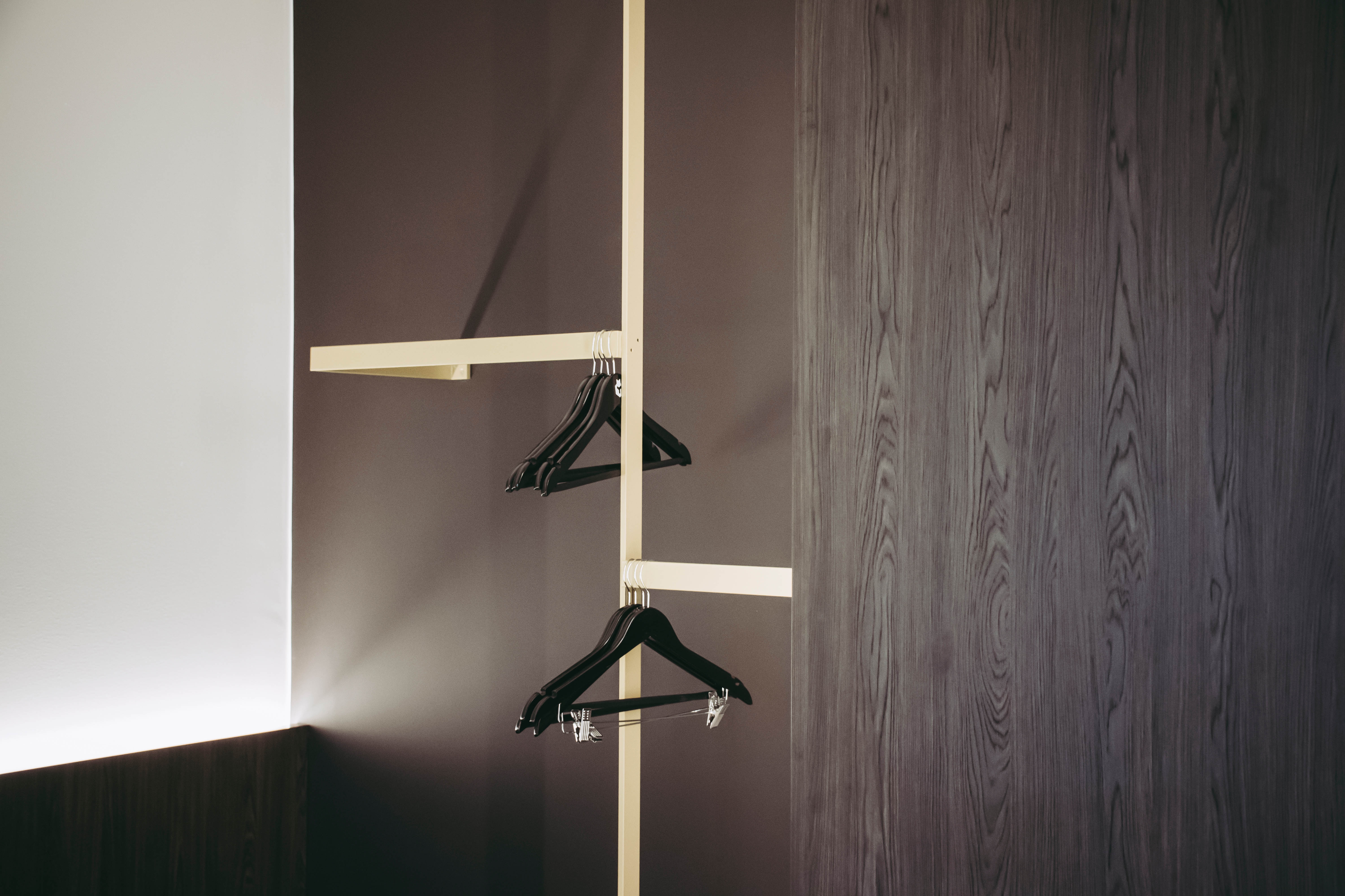 Inside the bedrooms, the panelling was extended to create built-in furniture. Open cupboards and storage areas for clothes are enhanced with brass accents