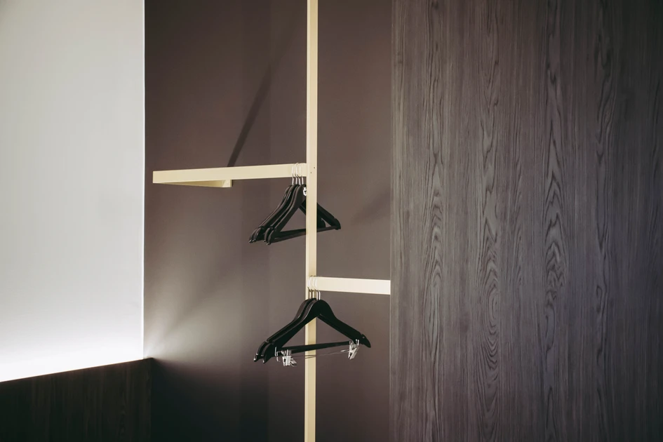 Inside the bedrooms, the panelling was extended to create built-in furniture. Open cupboards and storage areas for clothes are enhanced with brass accents
